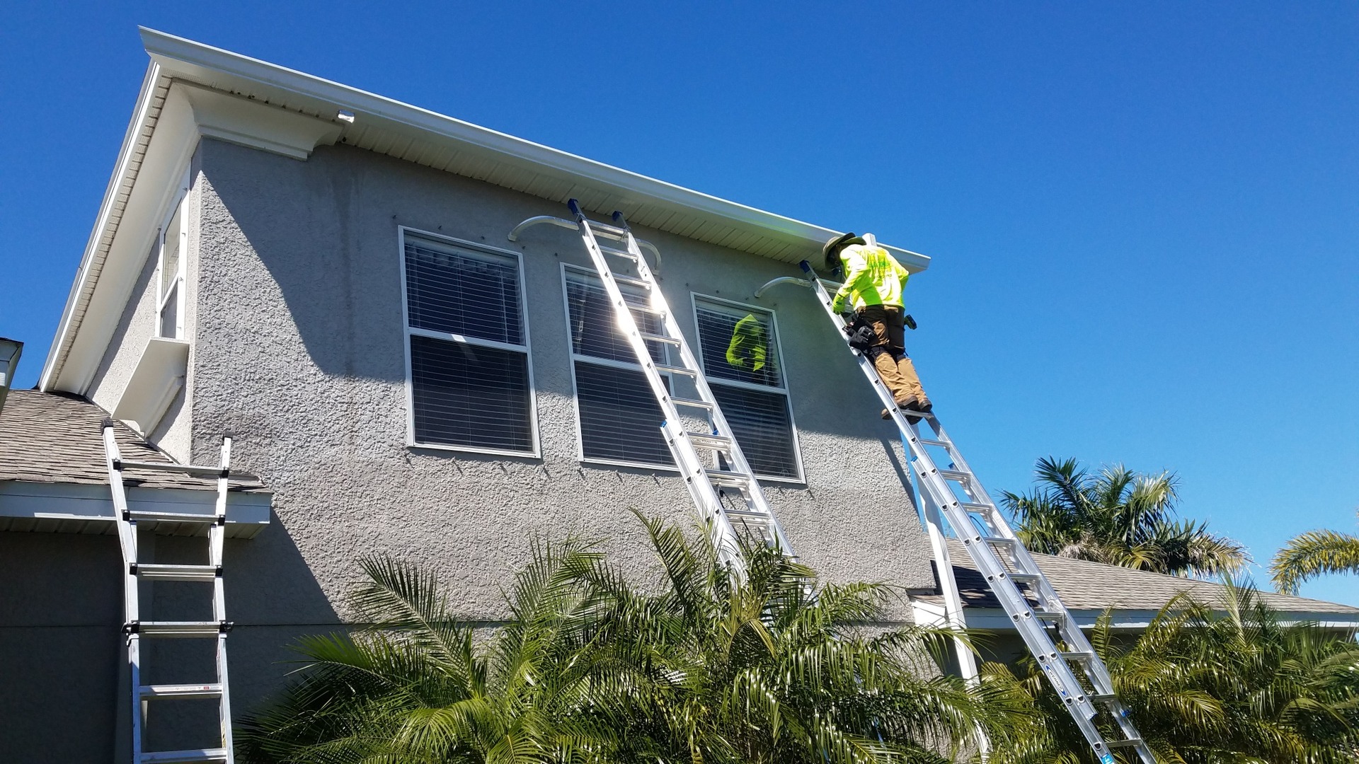 Technician performing gutter repair on a Tampa Bay home